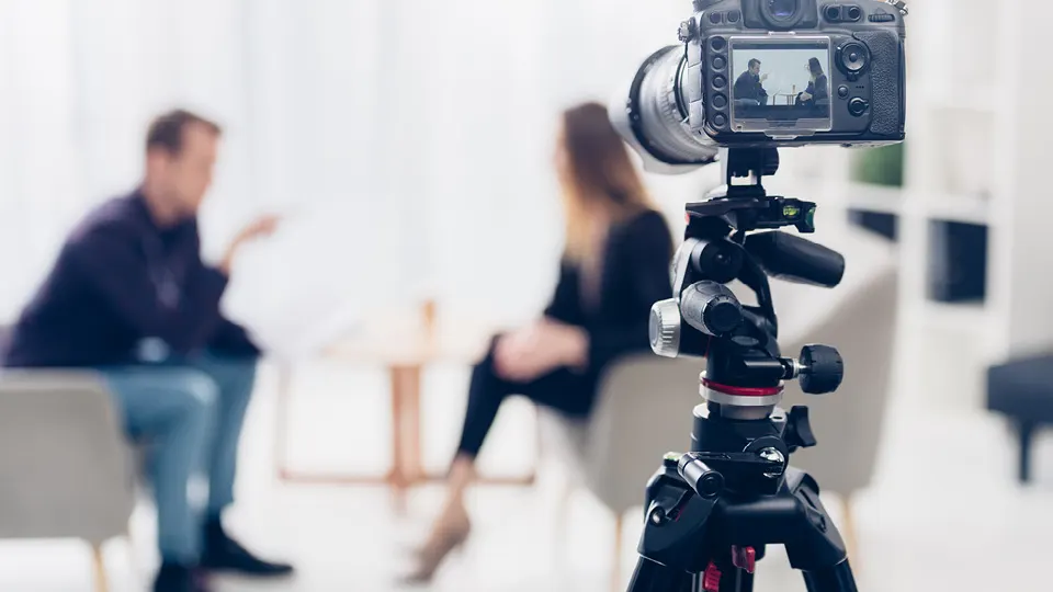 Dos en una entrevista frente a una cámara